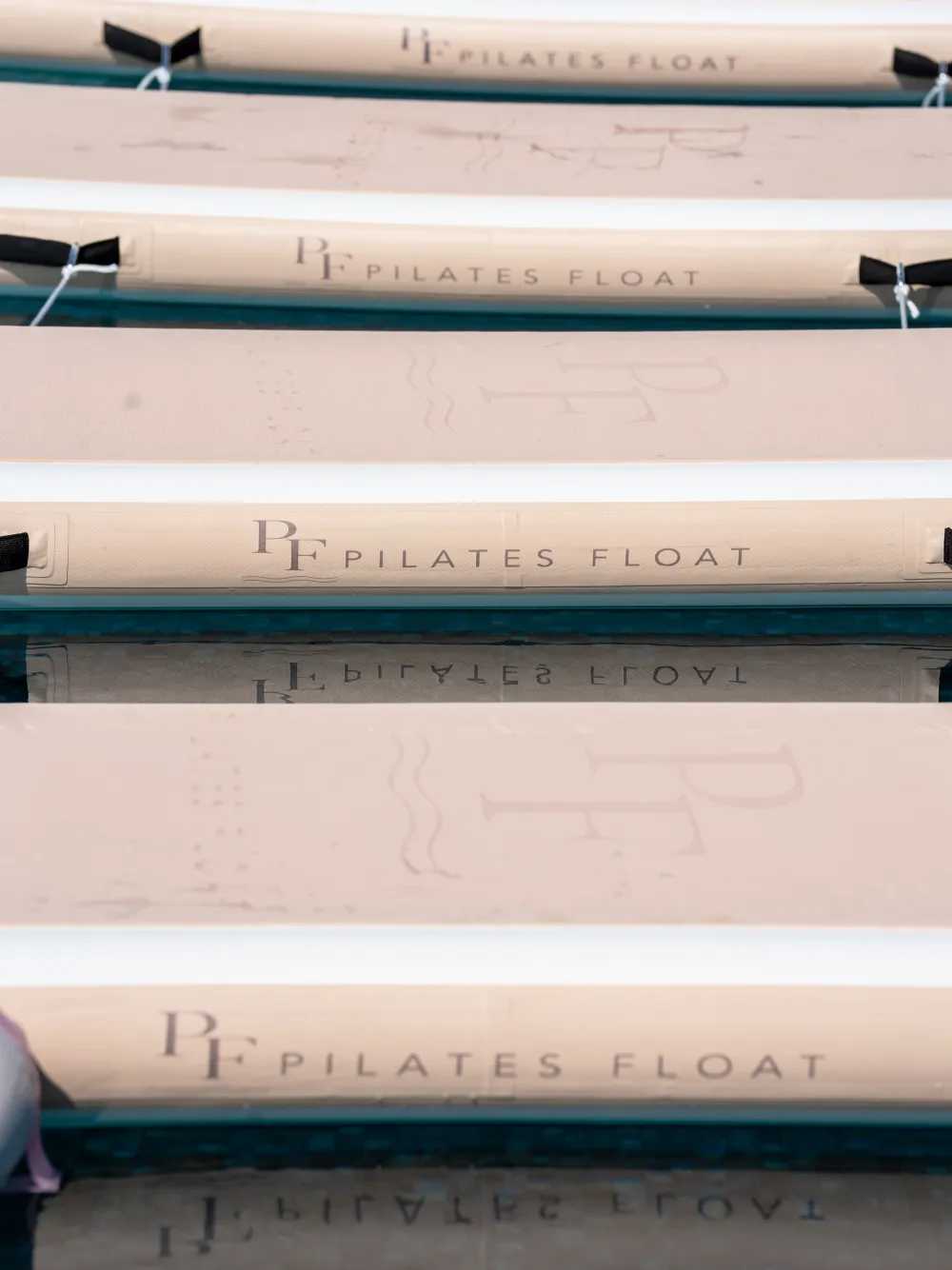 A row of Pilates Float boards, the logo repeated along each one